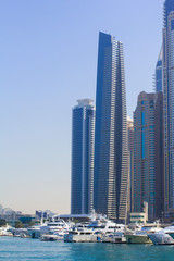 Fototapeta na wymiar background view from the water to the Dubai Marina maritime entrance for water transport, and a group of modern skyscrapers, Dubai, UAE