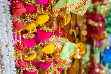 Colorful fabric decorations on display for sale in Chandi Chowk Old Delhi. These flowers, beads and bells designs are popular in weddings, festivals and events.