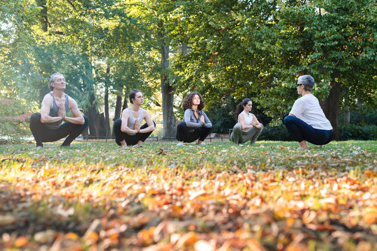 Group of women practicing yoga in park