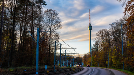 Fototapeta premium Germany, Urban cityscape of stuttgart city with view to famous landmark tv tower behind colorful trees in autumn season with many cars on the road
