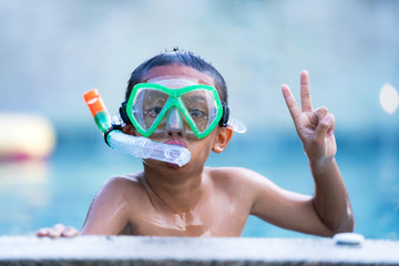 Obraz na płótnie Canvas View of boy with swim glasses floating in the swimming pool