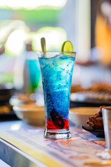 Refreshing blue mocktail is served on a tall glass.