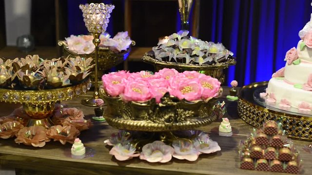 Gorgeous and wonderful candies, ready to be tasted, delicious wedding cake with miniature grooms on top. All made by hand. Pan capture.