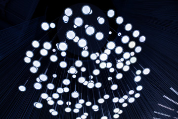 Many light bulbs that go down with their cables from the ceiling creating a unique optical illusion.
