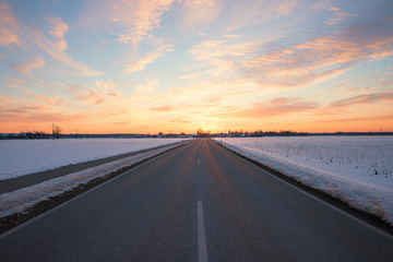 straight country road in winter landscape at sunset, Brunnthal village, upper bavaria