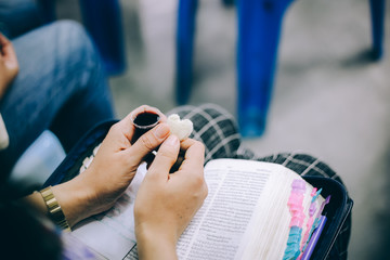 Hands hold a red wine cup in Holy communion