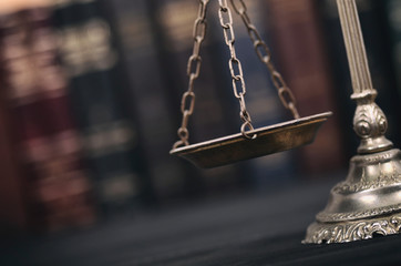  Scales of Justice on a black wooden background.