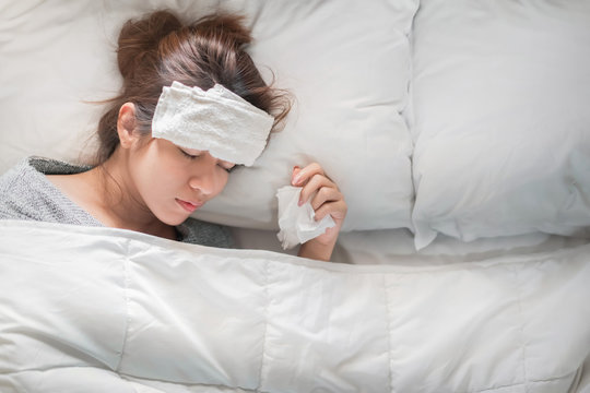 Sick asian woman have hight fever flu and illness on bed in bedroom, Medical and health concept, Selective focus.