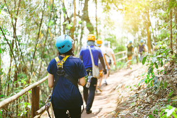 Be hide people go to Zip line in forest with sunlight,Adventure concept