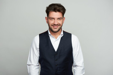 Handsome man is smiling isolated on grey background