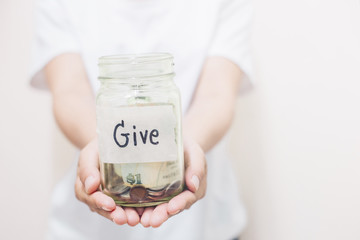  Coins in glass jar with Give word written text label for giving and donation concept