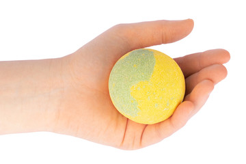 Yellow green bath bomb in a female hand