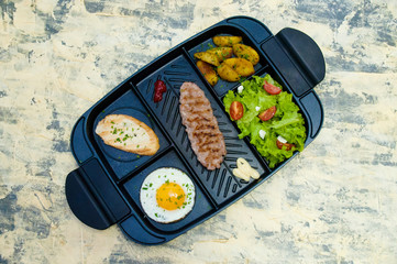 Breakfast, fried steak or cutlet, salad with tomato and green vegetables, toast, potato, egg top view, light background. The concept of healthy diet, diet, menu, good nutrition.