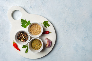 Set of fragrant spices on a wooden white Board. Pepper, mustard seeds, herbs