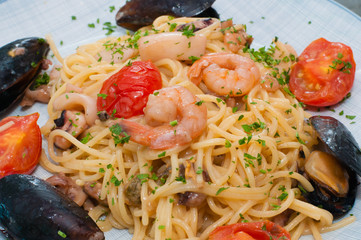 Spaghetti pasta with shrimp, mussels, tomatoes and cheese. Tasty, traditional food from Italy