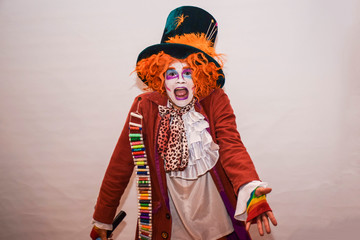 The character from “Alice's Adventures in Wonderland” by Lewis Carroll is a Dummy or a Shoemaker. Young man in a suit of a mad, surprised hatter on a white background. - obrazy, fototapety, plakaty