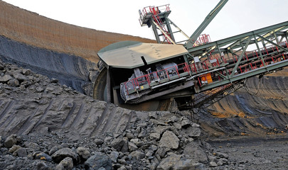 A large excavator digging at a surface mine.