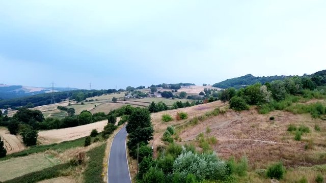 Accending drone shot over a car park and farmland.