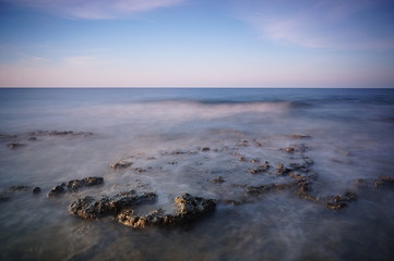 the atmosphere of the beach or the coast before the afternoon with calm waves and sunny weather set against the background of the high seas and mountains or plateaus