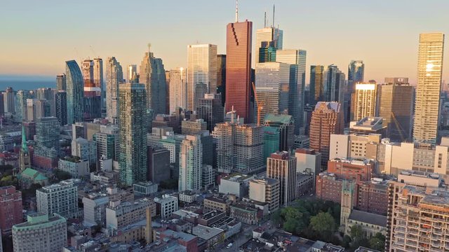 Aerial: Establishing shot of apartments & downtown Toronto city skyline at sunrise. Ontario, Canada.