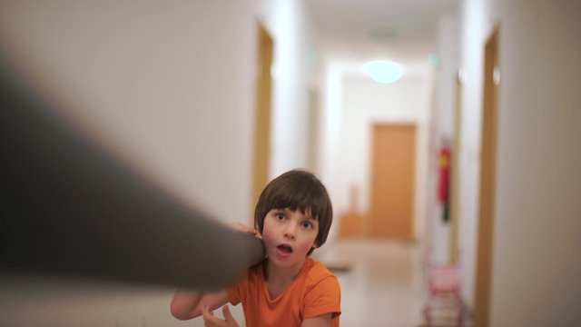 The boy holds a long pipe in his hands and feet glove.