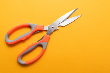 large kitchen metal scissors on yellow background