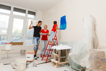 Young happy family doing repairs in the house for sale. Concept of house selling. Home repair.