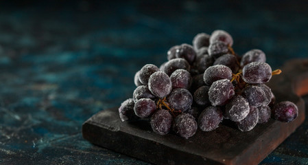 Frozen Black ripe grape for dessert on black background.