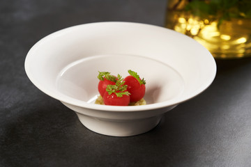 Fresh peeled chili tomatoes and minced cucumbers on dark background