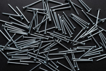 construction metal nails on black background