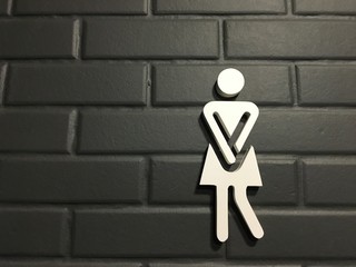 Women restroom pictograms. Funny toilet signing on black brick wall, desperate pee woman wc icons,...