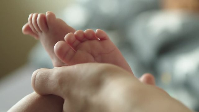 Baby feet in mother hands. Newborn Baby's feet on female hands closeup. Little baby feet in hands of mother. Miracle of life.