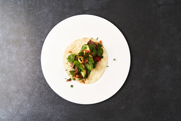 Mexican tacos with beef, tomatoes, avocado, chilli and onion