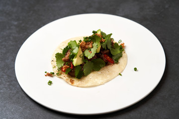 Mexican tacos with beef, tomatoes, avocado, chilli and onion