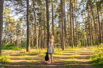 Woman in summer with a bag at the crossroads of two roads