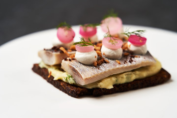 Obraz na płótnie Canvas Smorrebrod with Baltic herring fish, smoked mousse and pickled onions