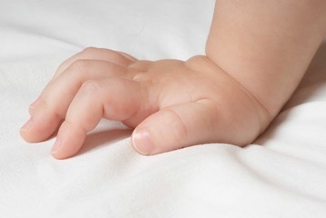 Baby's Hand On Bed