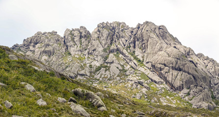 Scenic rugged granite mountains of the Serra da Mantiqueira (Mantiqueira Mountain Range) with grassy parts against bright background, upper Itatiaia, Brazil