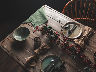 Holiday table setting with Linen napkins and the red berry branch decor. Scandinavian style. Wooden table. The concept of the holiday. Close up © Екатерина Кравченко