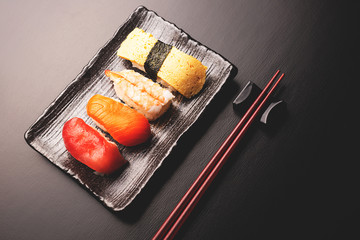 Set of tasty sushi on black background.