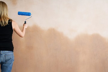 Woman Painting Wall With Paint Roller