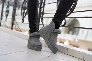 gray female stylish low uggs with fashionable stitching on legs indoors