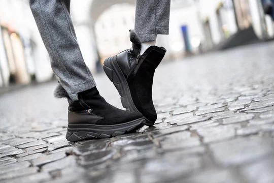 Close-up black womens suede ugg boots demi season with flat rubber soles on  legs on street in real conditions Stock Photo | Adobe Stock