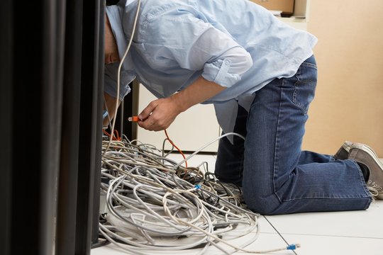 Man Working On Tangled Computer Wires