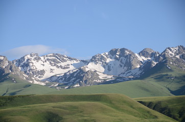 panorama of kyrgysian mountains with meadow in foreground