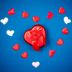 Red heart with a gift to Valentine's Day on a beautiful blue background. Heart pendant. Space for text. Red heart. Valentine Day.