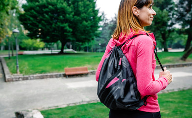 Athlete woman with backpack going to the gym outdoors
