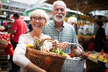 Foto op Canvas Mature couple shopping vegetables and fruits on the market. Healthy diet. © NDABCREATIVITY