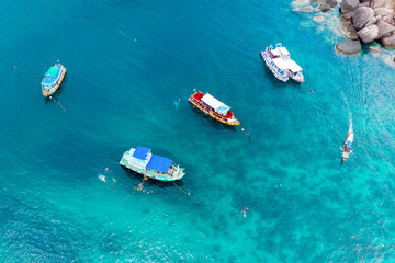 Fototapeta premium Top view of boats and divers in blue water.