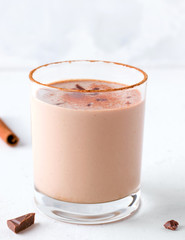 Lassi chocolate a traditional Indian drink next to pieces of chocolate and a stick of cinnamon